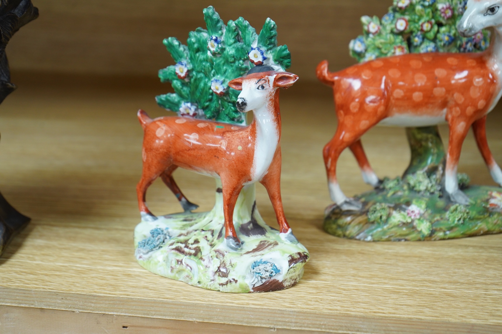 Three early 19th century Staffordshire pottery models of deer, largest 16cm high